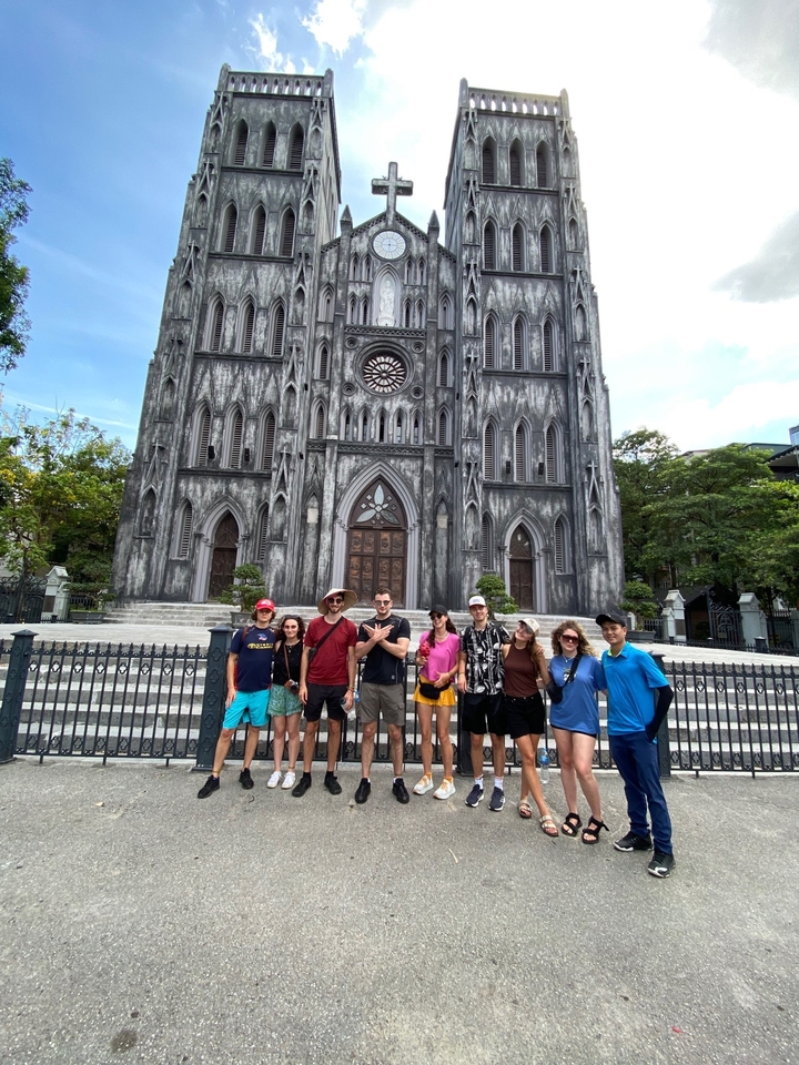 Un groupe de personnes debout devant une grande cathédrale gothique.