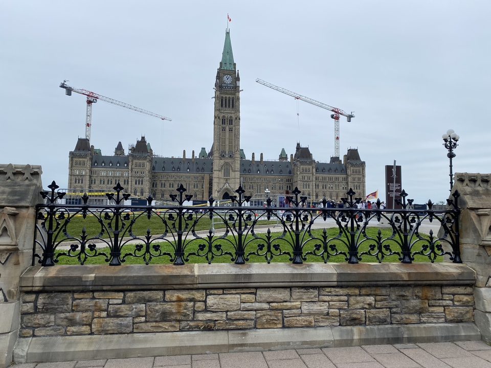 Le Parlement du Canada à Ottawa avec des grues en arrière-plan.