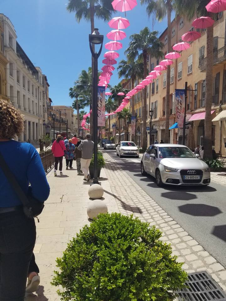 Décoration de rue avec des éléments roses et des gens qui marchent.