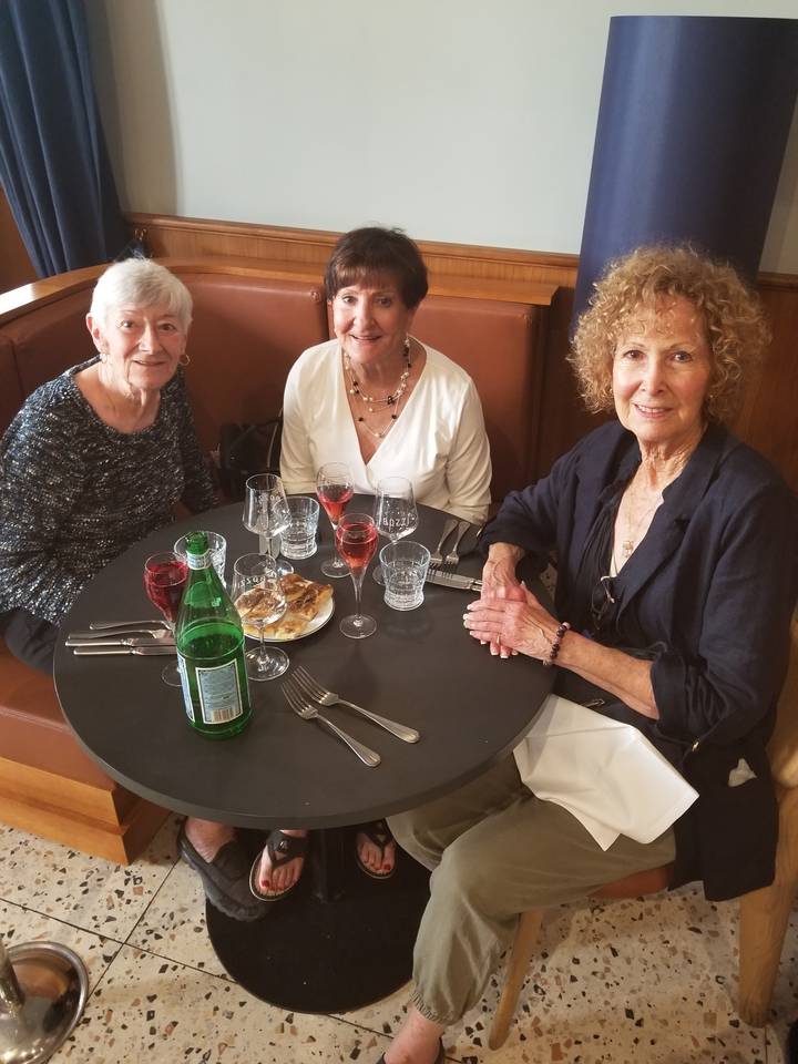 Trois femmes assises à une table à manger à l'intérieur.