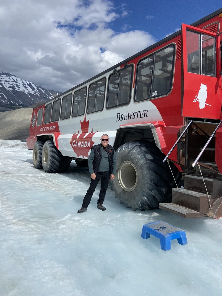 Personne près d'un grand véhicule d'exploration sur glace.