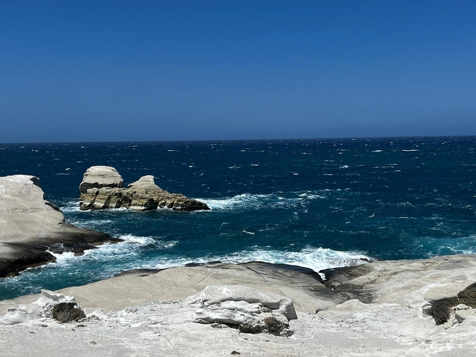 Une côte rocheuse avec des vagues bleues de l'océan.