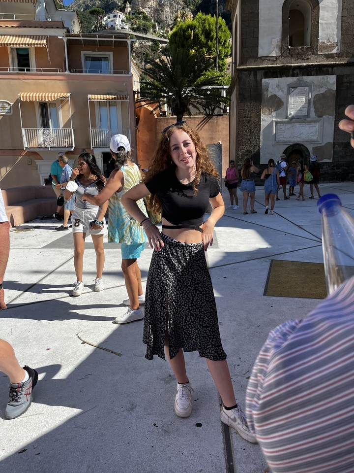 Personne debout dans un espace public animé avec des gens autour.