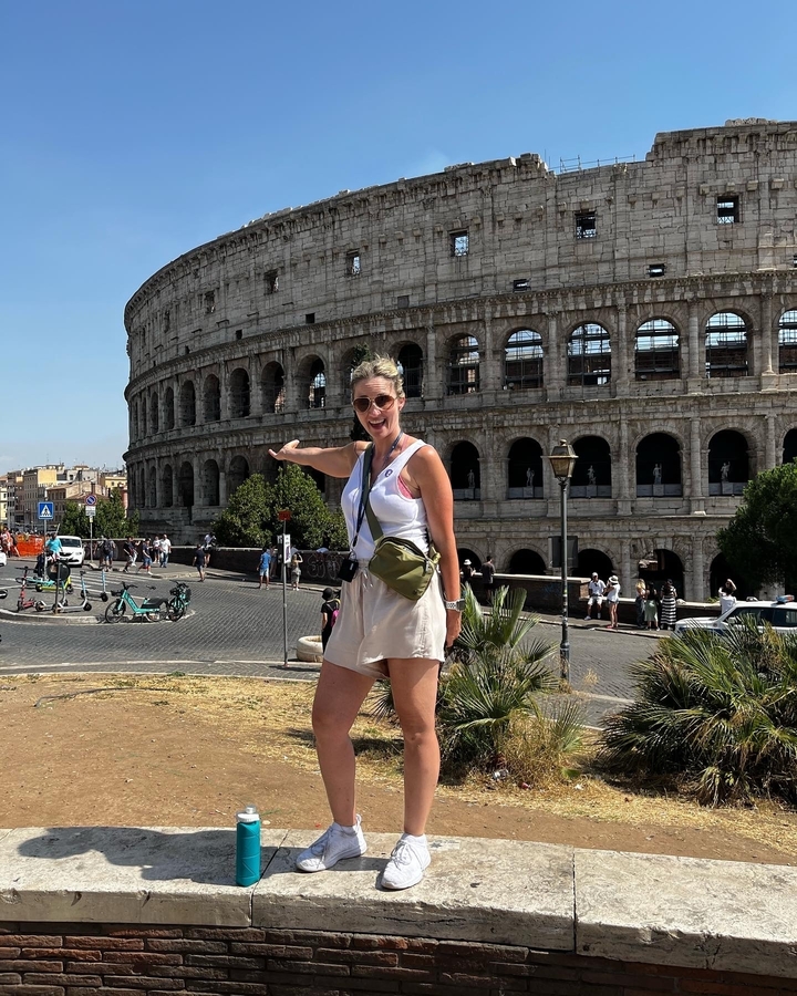 Personne posant devant le Colisée à Rome.