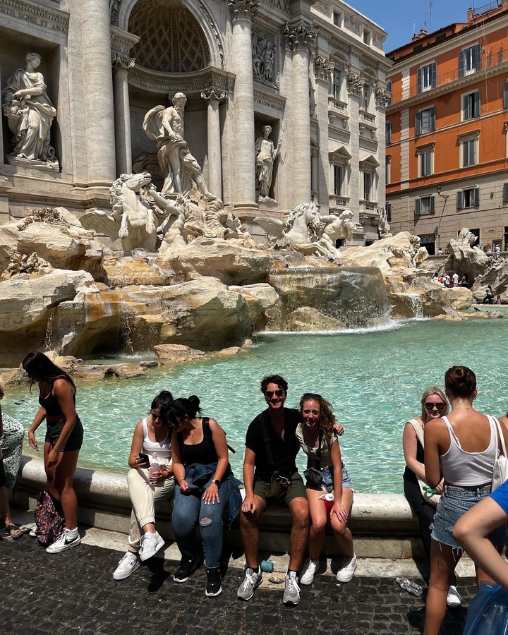 Groupe de personnes devant la fontaine de Trevi à Rome.