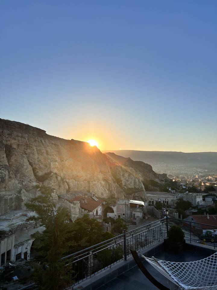 Soleil couchant derrière un paysage rocheux.