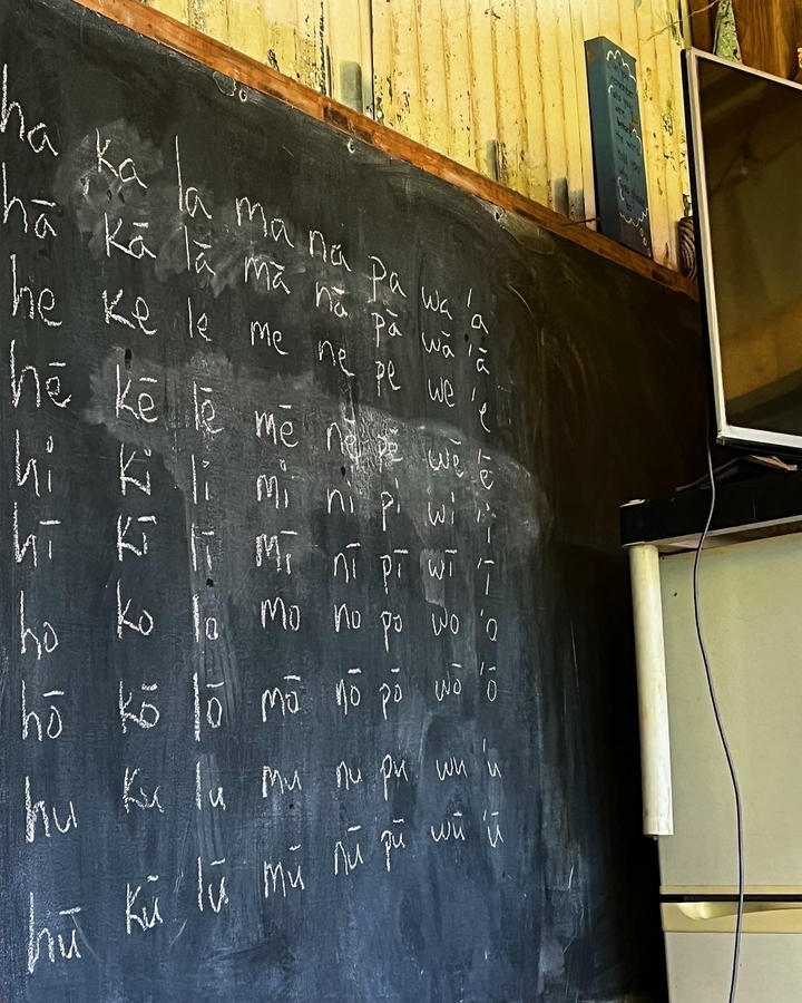 Tableau noir avec des mots écrits dans une écriture non anglaise.