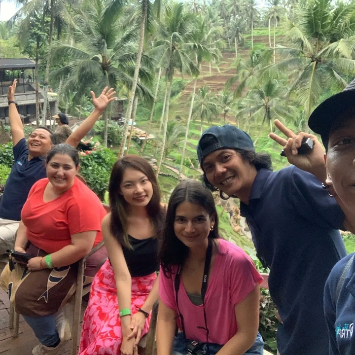 Un groupe de personnes devant des rizières en terrasses.