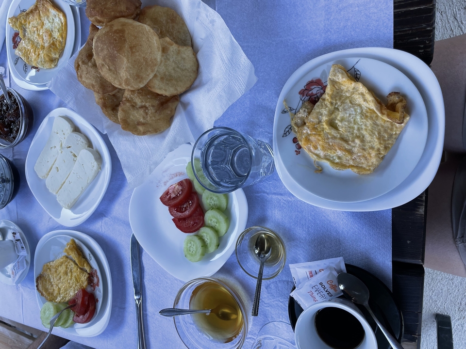 Traditional Albanian breakfast spread with eggs, cheese, fresh vegetables and fried bread