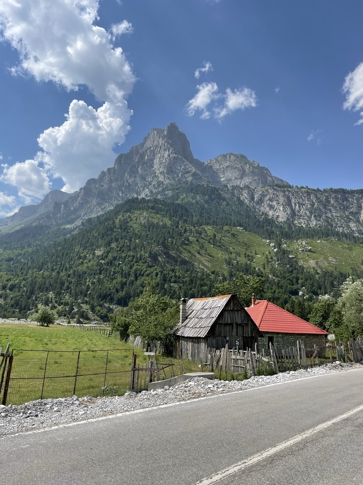 Picturesque alpine valley with dramatic peaks towering over traditional wooden cottages