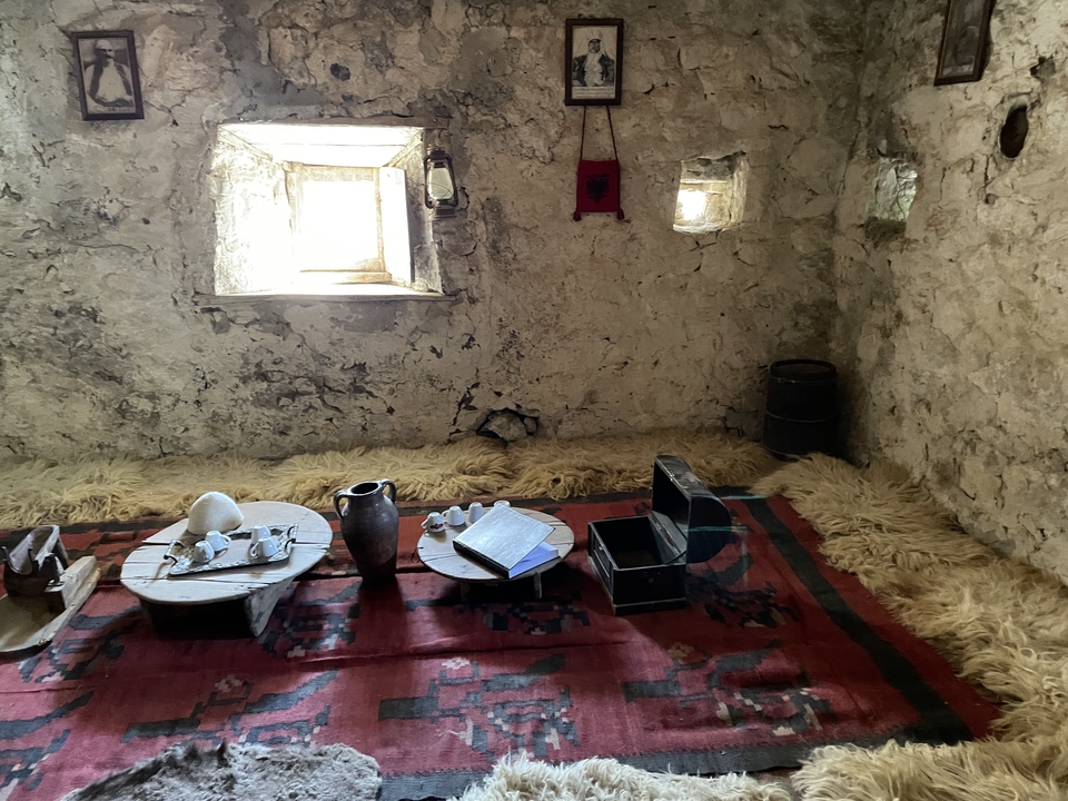 Rustic interior of a traditional stone house with low window, sheepskin rugs and local artifacts