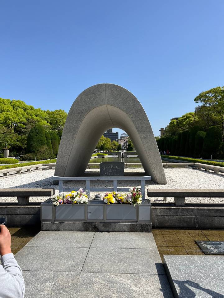 Parc du Mémorial de la Paix d'Hiroshima avec des fleurs et un ciel dégagé.
