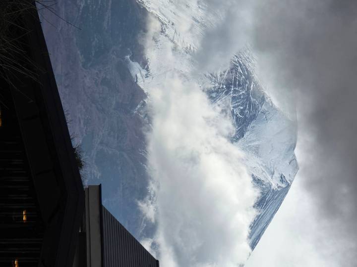 Sommet de montagne enneigé perçant à travers les nuages.