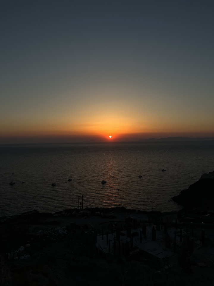 Stunning sunset over the ocean with silhouettes of boats.