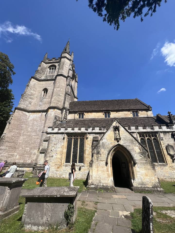 Cathédrale avec une haute flèche vue depuis un jardin.