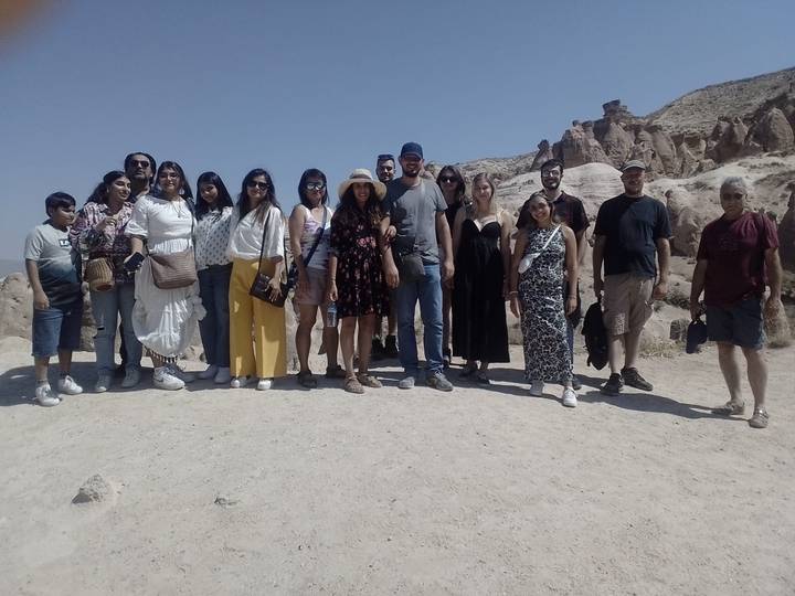 Large group of people posing in a desert landscape