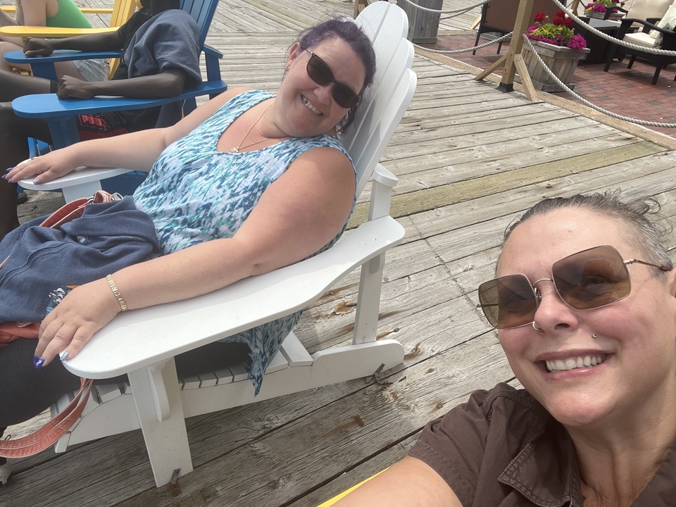 Deux femmes se prélassant sur des chaises longues sur une promenade en bois.