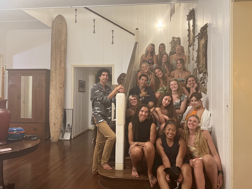 Un groupe de jeunes adultes posant dans un escalier à l'intérieur.