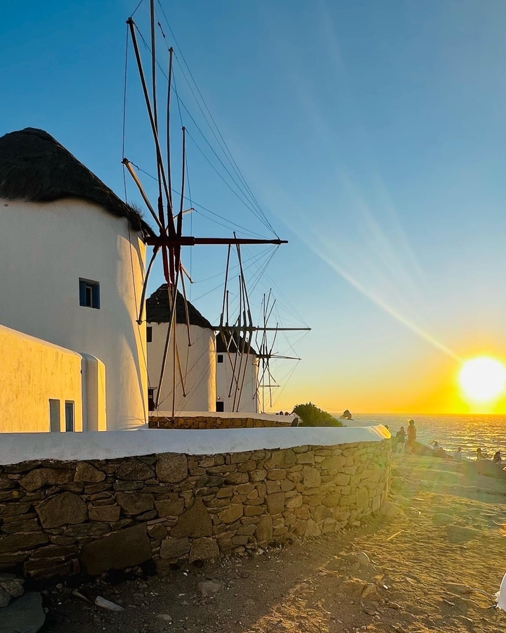 Vue du coucher de soleil sur les moulins à vent au bord de la mer.