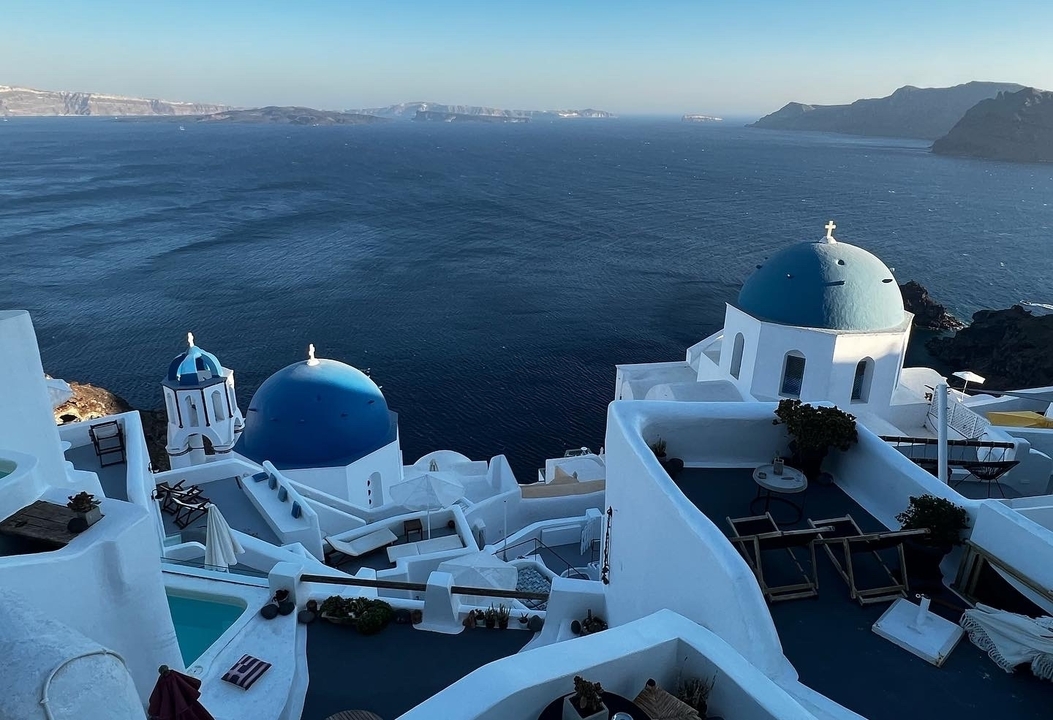 Églises aux dômes bleus surplombant la mer.