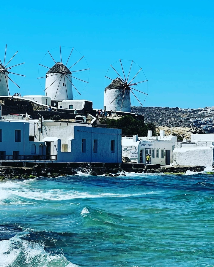 Littoral avec bâtiments blancs et moulins à vent.