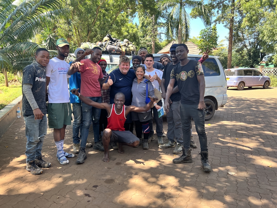 A group of people posing in front of a vehicle.