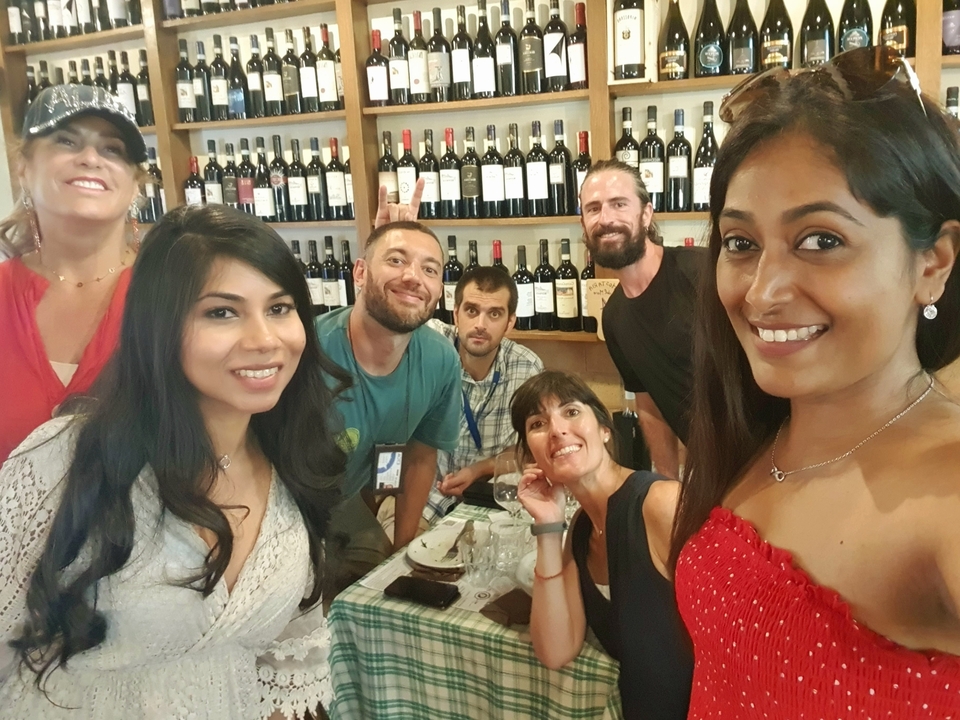 Groupe de personnes dans une cave à vin ou un restaurant avec des bouteilles en arrière-plan.