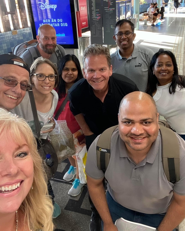 Selfie de groupe de touristes souriants.