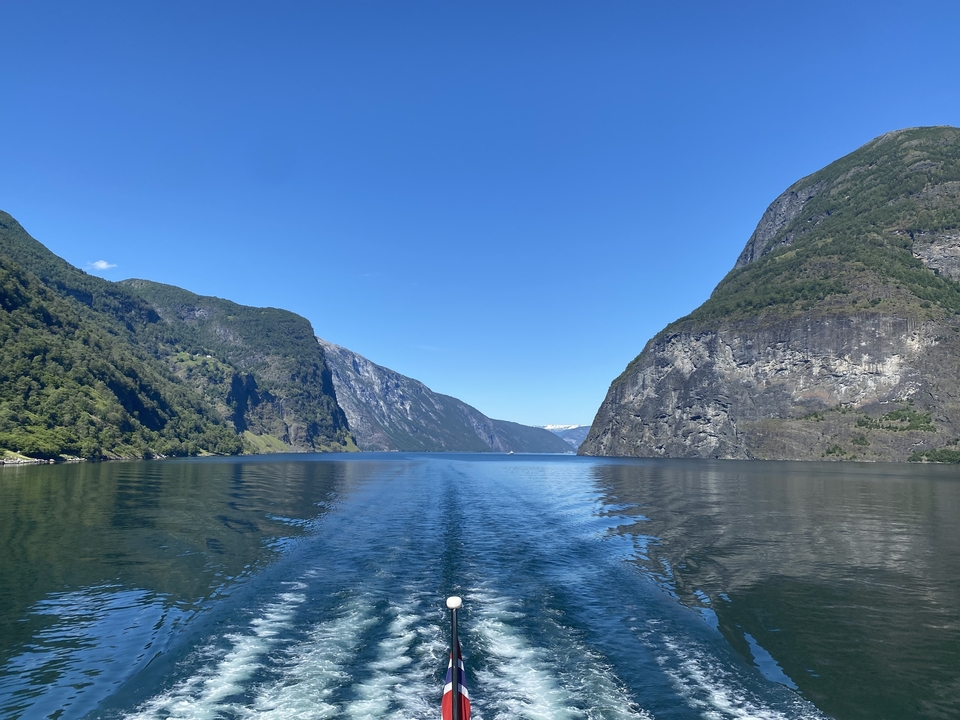 Vue panoramique d'un fjord avec une eau claire et des montagnes escarpées.