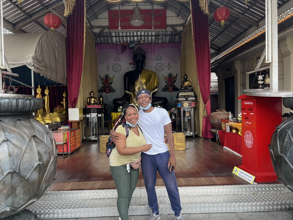 Deux personnes posant devant l'entrée d'un temple.
