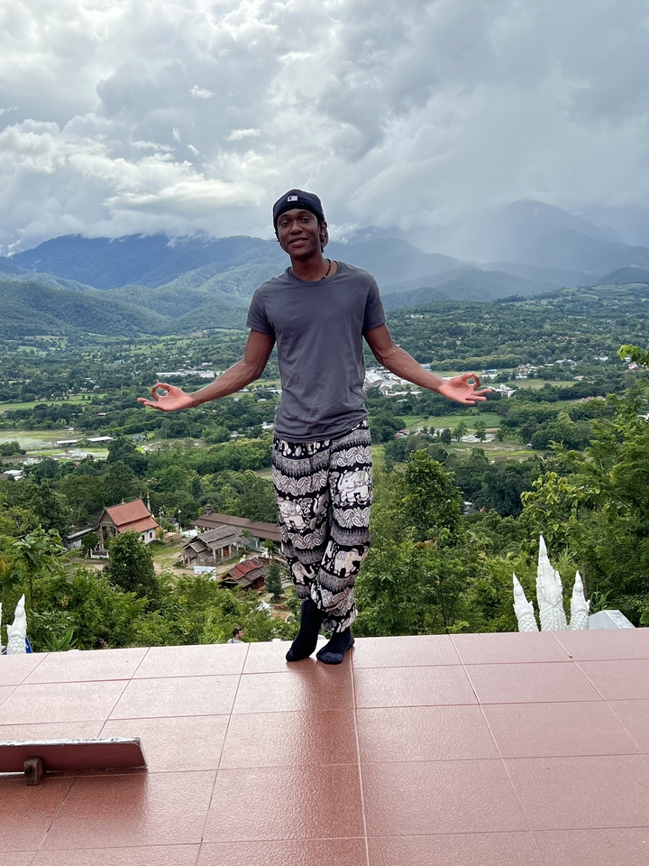 Une personne qui pose devant un paysage pittoresque.