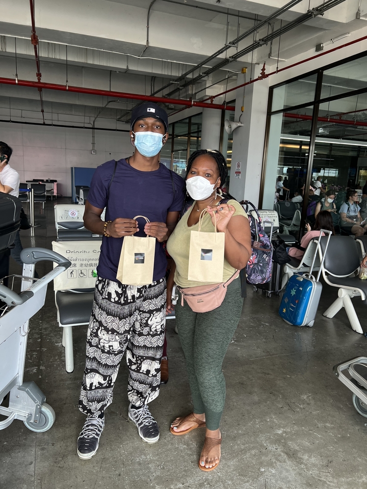 Deux personnes dans un aéroport tenant des sacs.