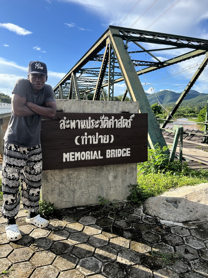 Une personne debout près d'un panneau de pont commémoratif.