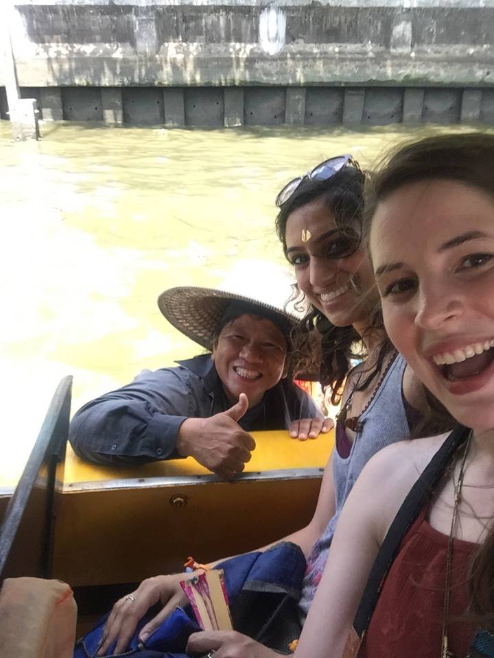 Three people smiling on a boat ride.