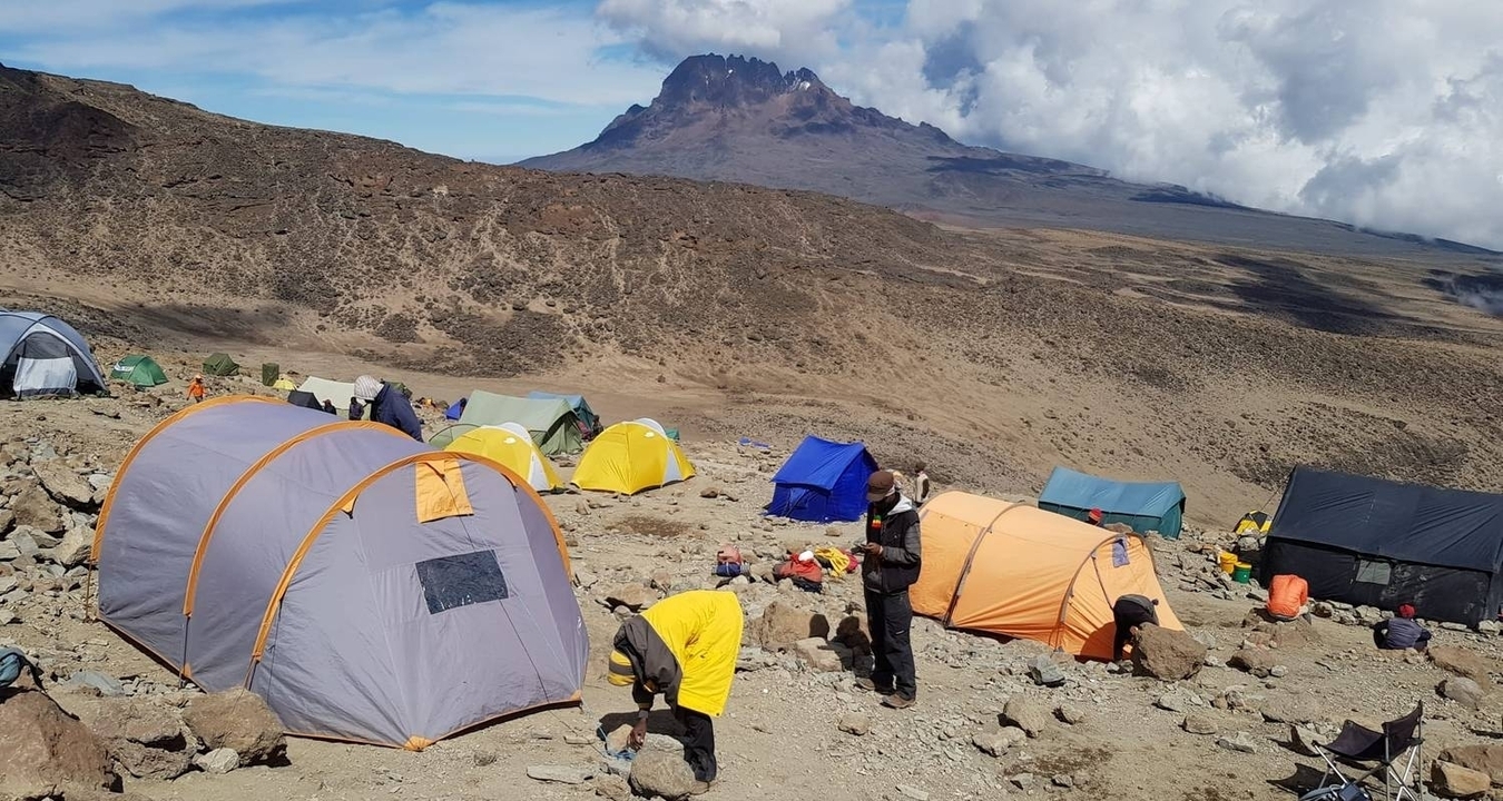 Tentes colorées et personnes dans un camp de base avec des montagnes