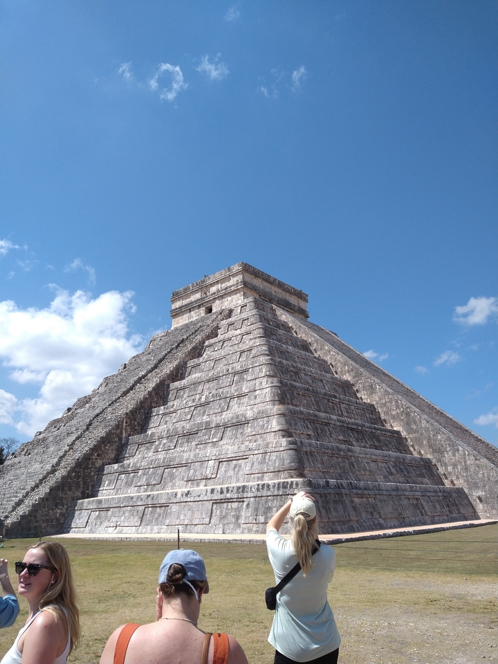 Une vue captivante d'une pyramide maya sous un ciel bleu clair.