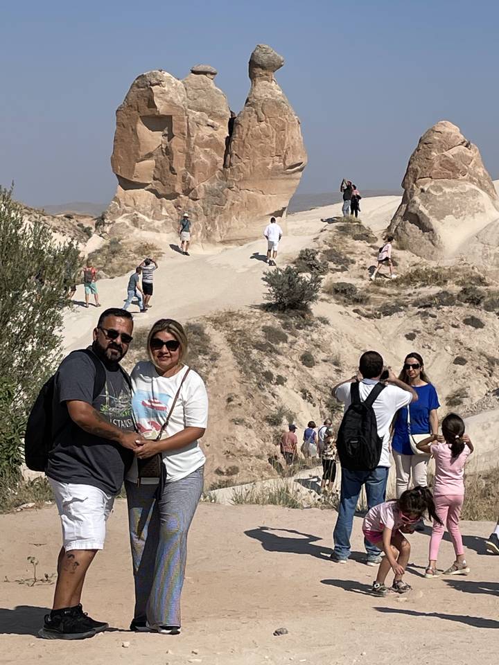 Groupe de personnes se tenant près de formations rocheuses.