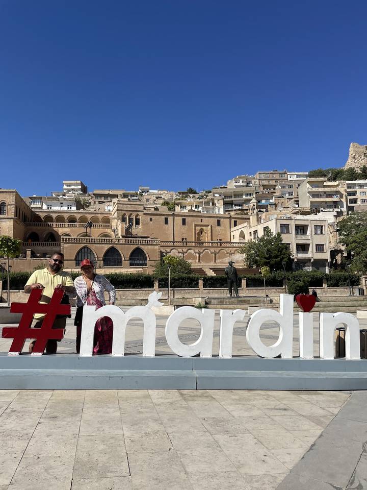 Deux personnes avec un paysage urbain et un panneau décoratif en arrière-plan.