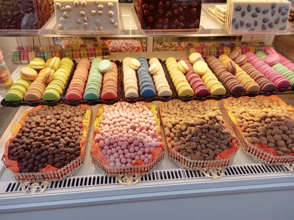 Des bonbons colorés assortis exposés dans une vitrine en verre.
