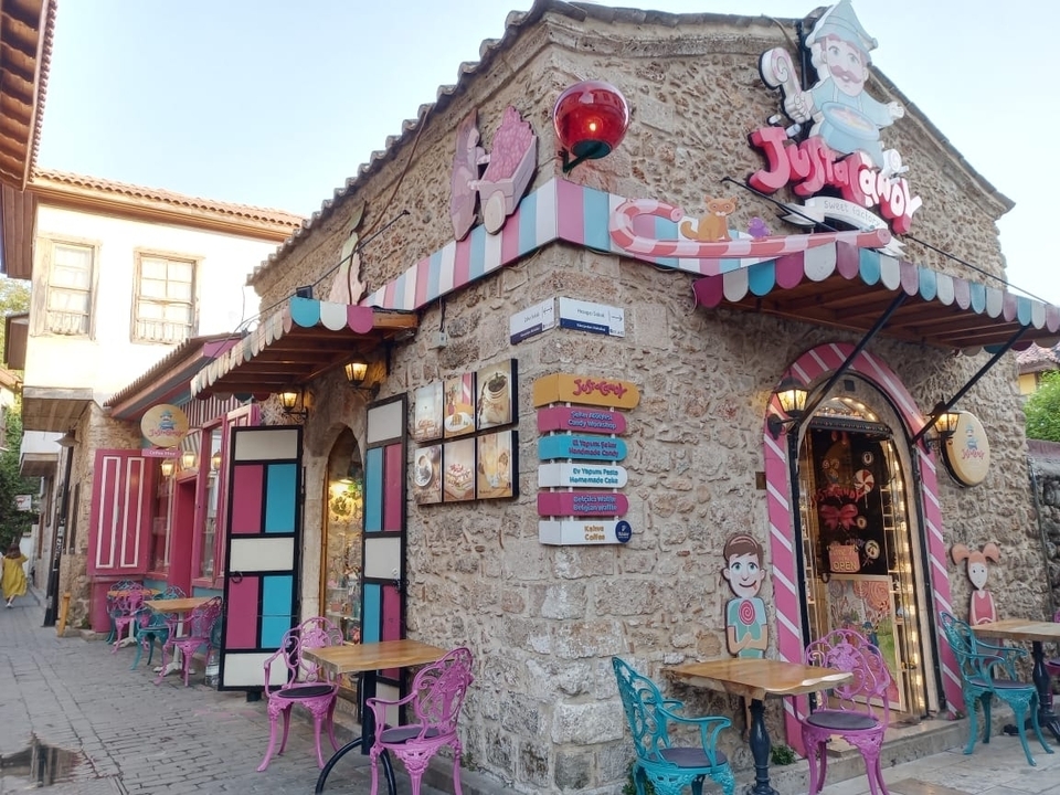Boutique colorée avec décor de dessins animés sur une rue pavée.