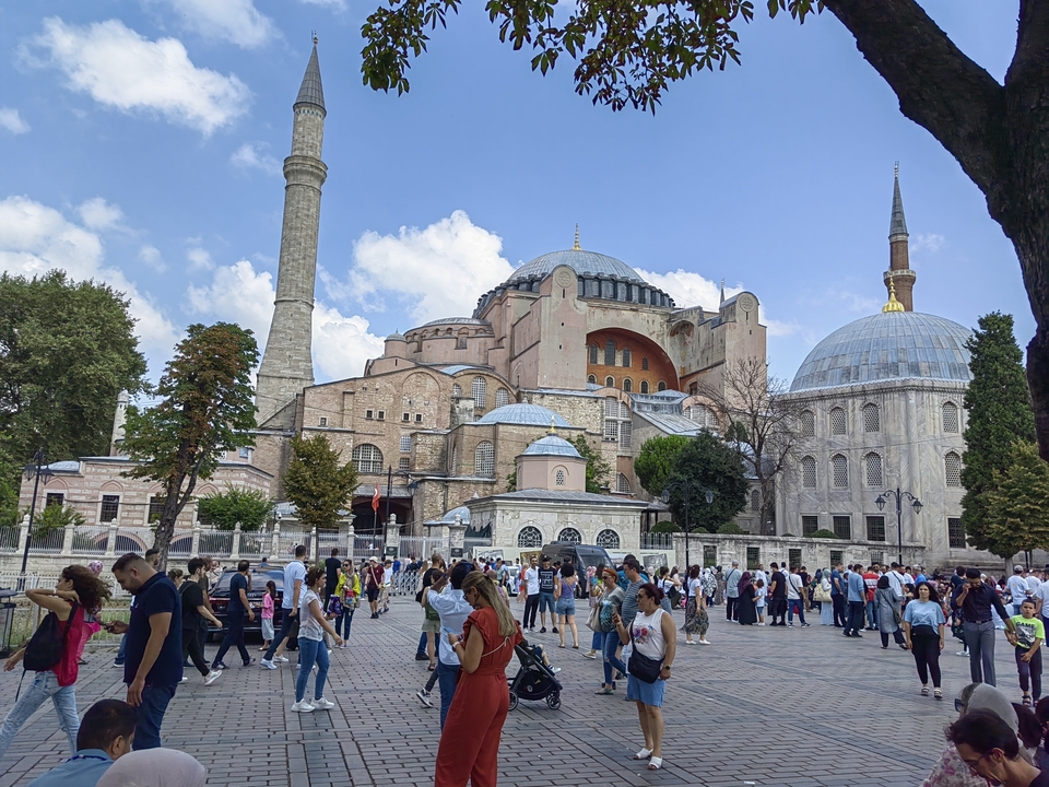 Mosquée historique avec un dôme et des minarets avec de nombreux touristes.