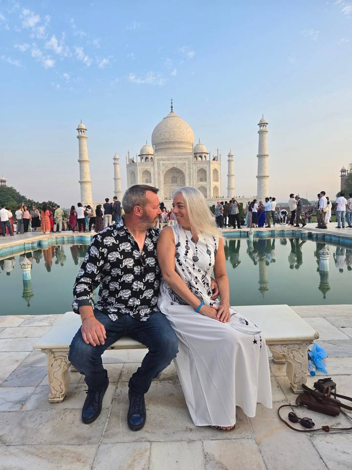 Deux personnes posant de manière romantique devant le Taj Mahal.