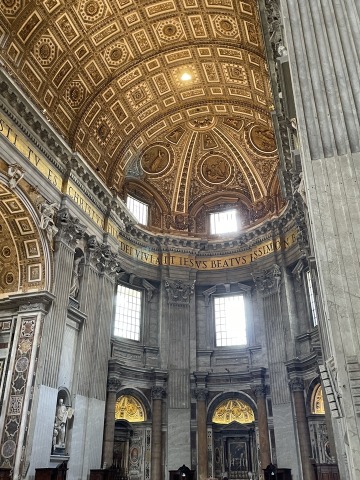 Dôme intérieur d'une basilique avec des inscriptions latines.