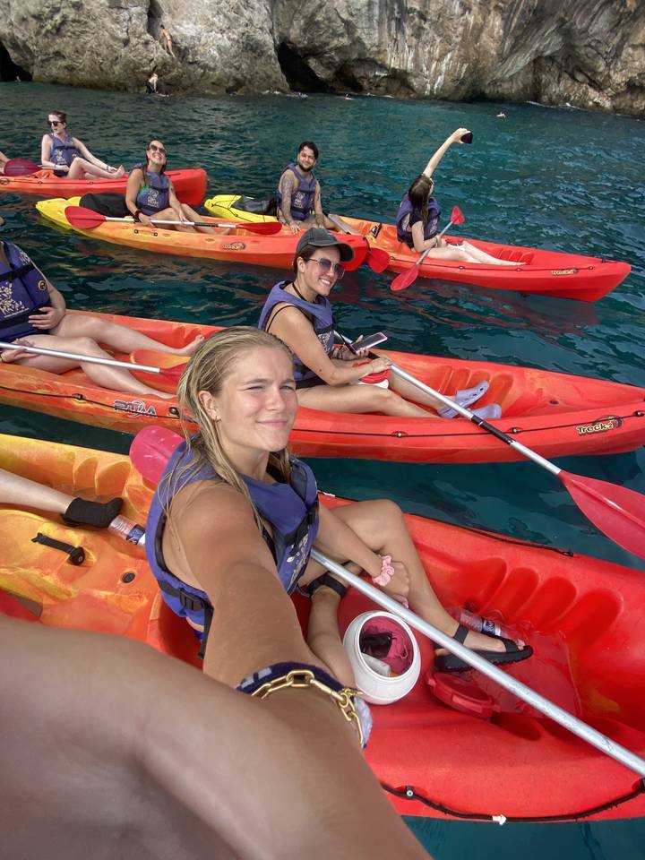 Groupe d'amis prenant un selfie en faisant du kayak sur des eaux claires.