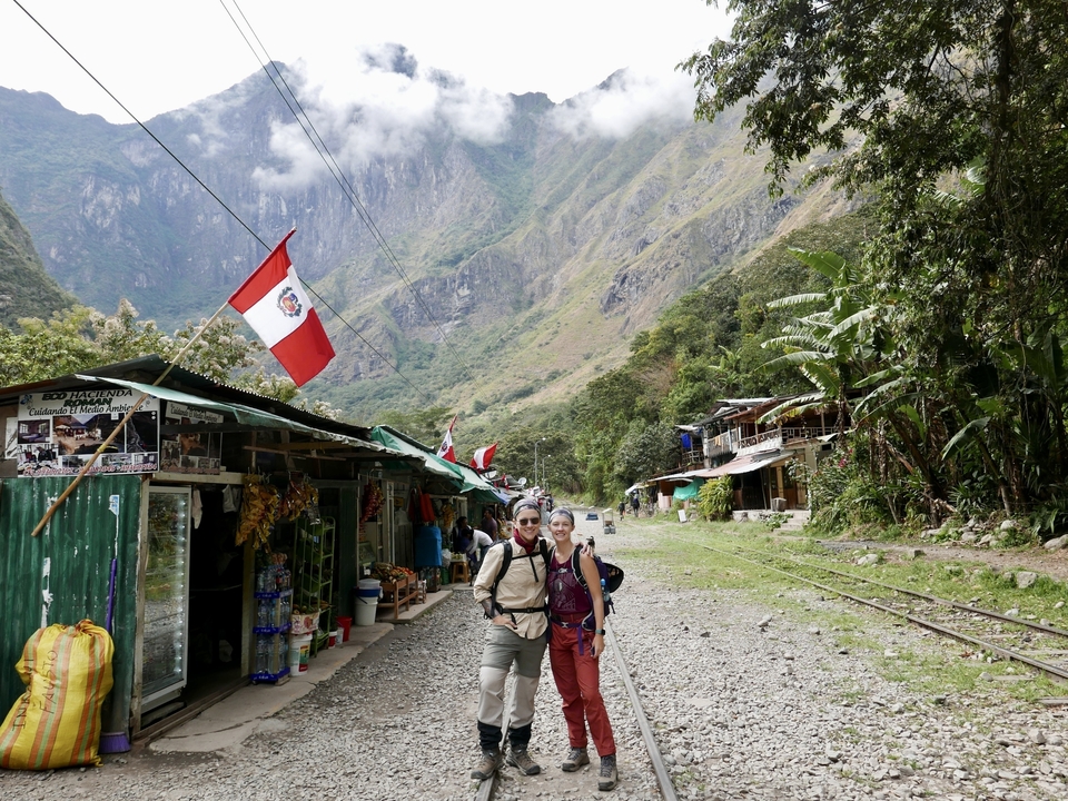 Deux randonneurs marchant le long d'un sentier andin avec des drapeaux.