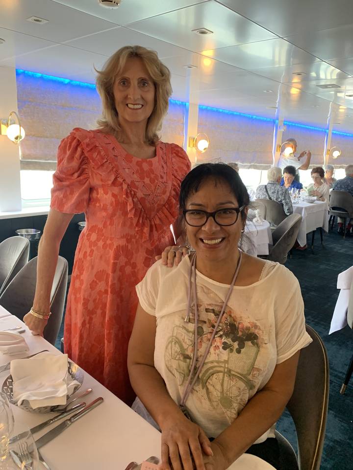 Two women smiling inside a restaurant.
