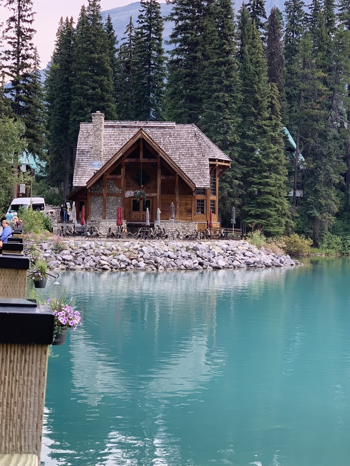 Café au bord du lac avec un décor pittoresque de montagnes et de forêt.