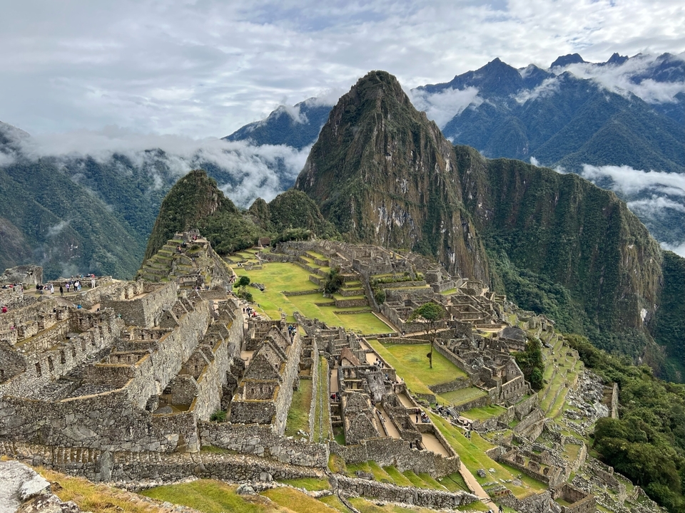 Vue panoramique du Machu Picchu avec une végétation luxuriante et de la brume.