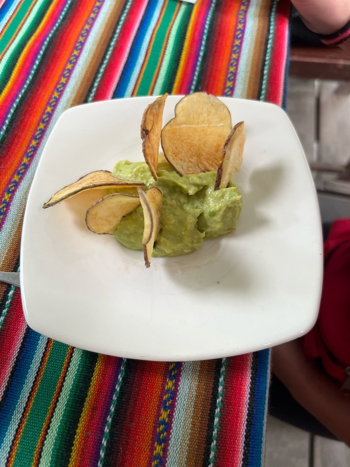 Petite assiette avec tartinade d'avocat et chips finement tranchées.