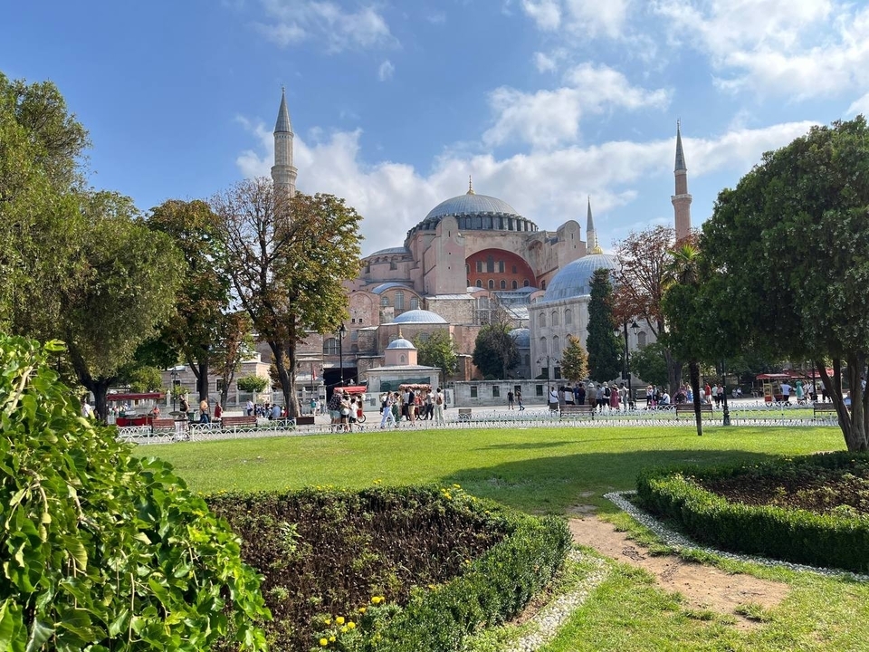 Bâtiment historique emblématique avec dômes et minarets entouré de jardins.
